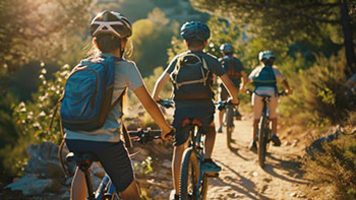 Kids mountain biking along trail in the forest