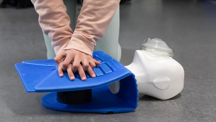 Person performing CPR on practice dummy