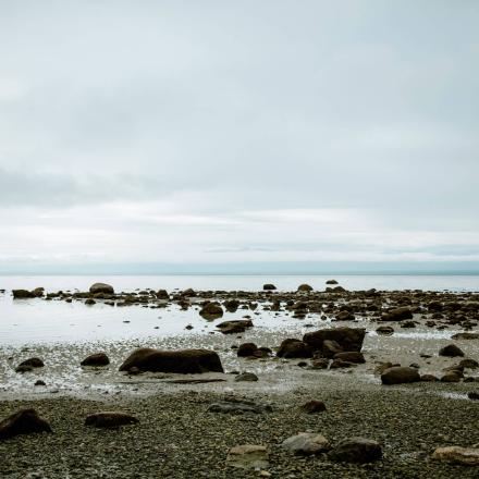 Rocky shoreline under a cloudy sky.
