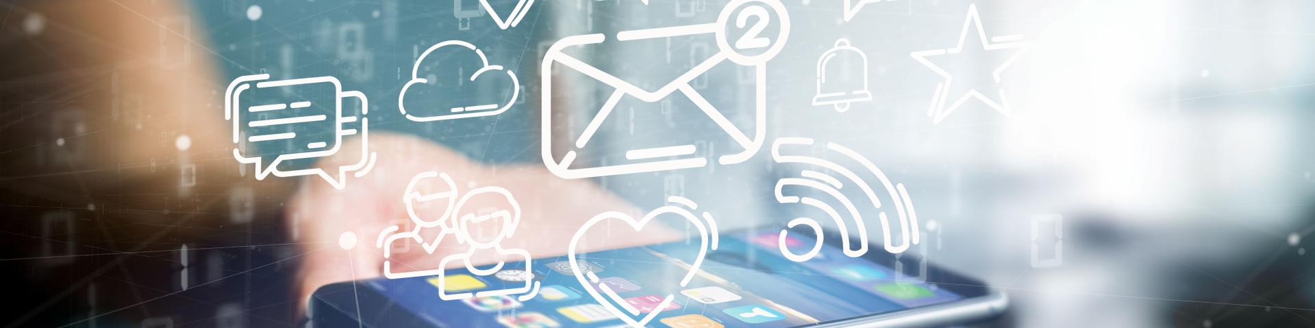 A hand holding a smartphone with digital communication icons above it.